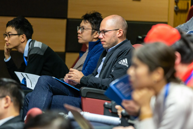A Close up of a group of people sitting at a conference.